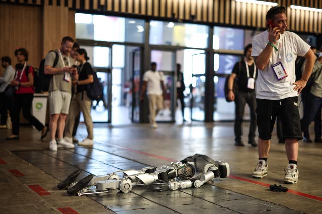 A Unitree Innov8 Robotics robot lays on the ground after falling during the VivaTech technology startups and innovation fair at the Paris Expo Porte de Versailles, in Paris on June 19, 2026. (Photo by SIMON WOHLFAHRT / AFP)