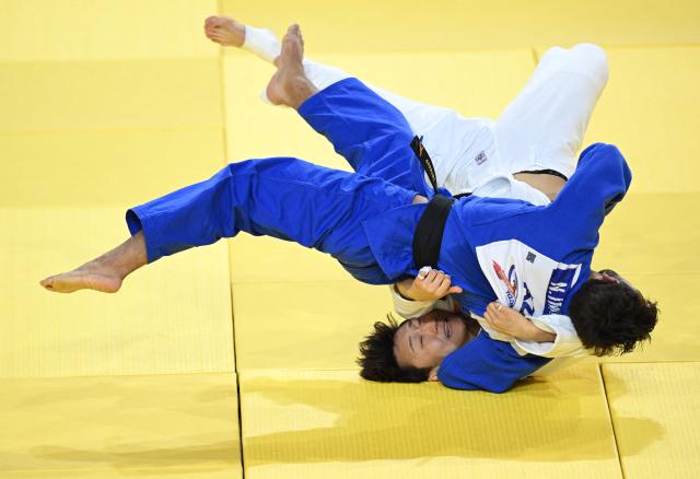 Kim  Chann-yeong of South Korea (white) competes with Nizami Imranov of Azerbaijan (blue) during their quarterfinal Men under 66kg at the Judo Ulaanbaatar Grand Slam 2026 in Ulaanbaatar, Mongolia on June 19, 2026. (Photo by ADEK BERRY / AFP)