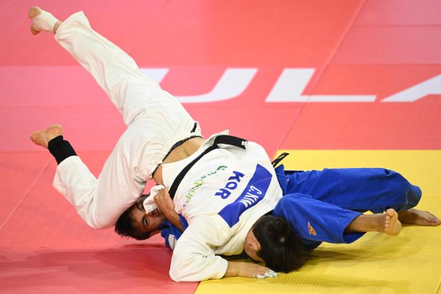 Kim  Chann-yeong of South Korea (white) competes with Nizami Imranov of Azerbaijan (blue) during their quarterfinal Men under 66kg at the Judo Ulaanbaatar Grand Slam 2026 in Ulaanbaatar, Mongolia on June 19, 2026. (Photo by ADEK BERRY / AFP)