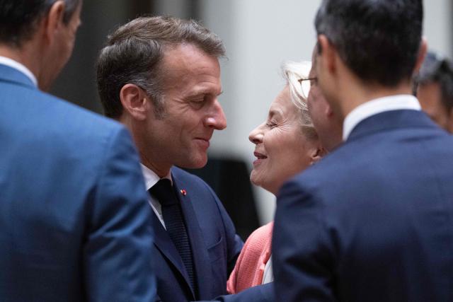 France's President Emmanuel Macron (L) welcomes European Commission President Ursula von der Leyen before the start of a round table meeting during the EU Summit at the EU headquarters in Brussels, on June 19, 2026. (Photo by JOHN THYS / AFP)