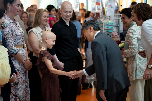 Emperor Naruhito of Japan (centre-R) shakes hands with a child during a visit at the Princess Máxima Centre for Pediatric Oncology in Utrecht on June 19, 2026, as part of Japan's imperial couple three-day visit to The Netherlands. (Photo by Lina SELG / AFP)