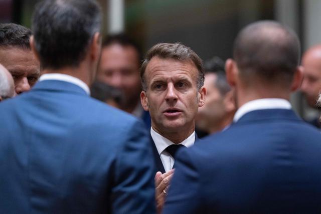 France's President Emmanuel Macron (C) speaks with Spain's Prime Minister Pedro Sanchez (L) speak before the start of a round table meeting during the EU Summit at the EU headquarters in Brussels, on June 19, 2026. (Photo by JOHN THYS / AFP)