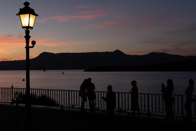 People enjoy the sunset in the old town of Corfu, on the Greek island of Corfu on June 14, 2026. (Photo by Roman PILIPEY / AFP)