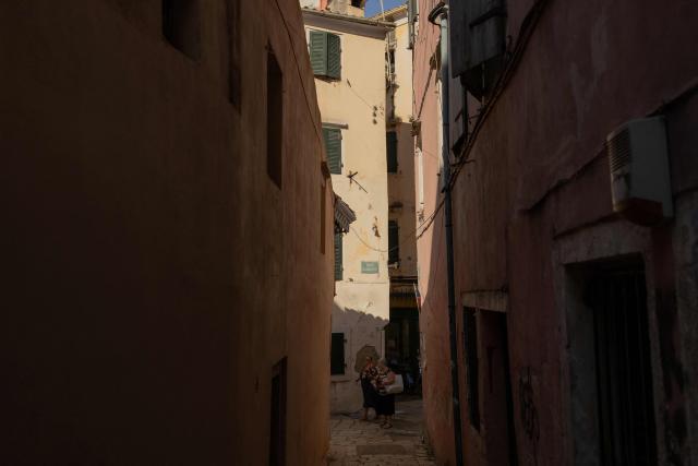 Women walk in the streets of the old town of Corfu, on the Greek island of Corfu on June 17, 2026. (Photo by Roman PILIPEY / AFP)