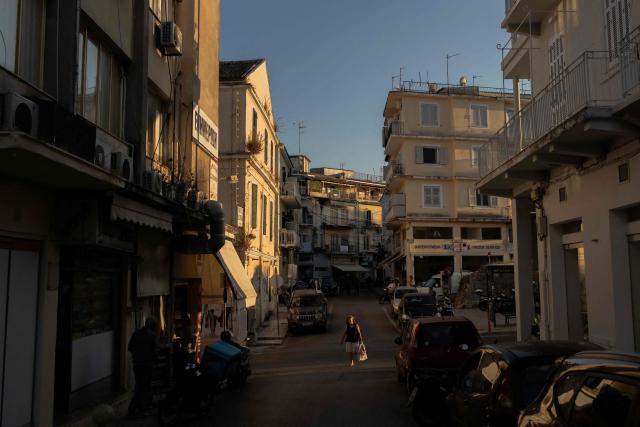 A woman walks in the streets of the old town of Corfu at sunset, on the Greek island of Corfu on June 17, 2026. (Photo by Roman PILIPEY / AFP)