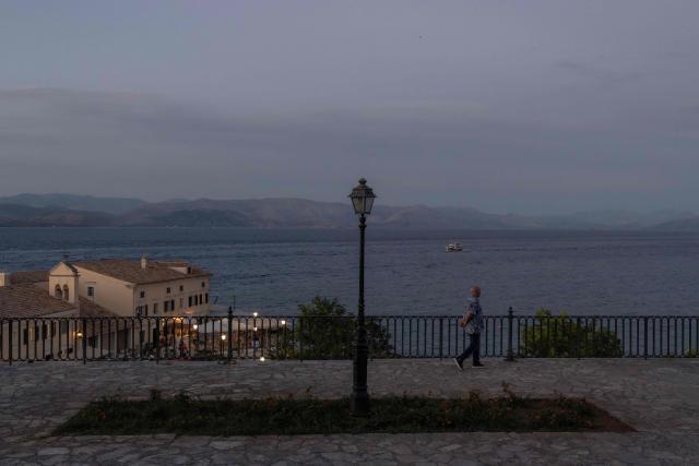 A man walks in the old town of Corfu at sunset, on the Greek island of Corfu on June 17, 2026. (Photo by Roman PILIPEY / AFP)