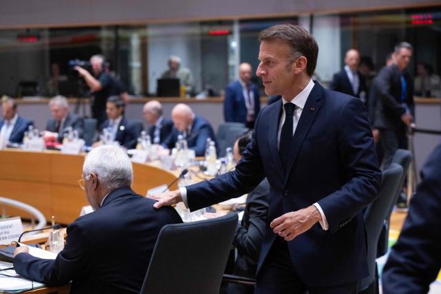 France's President Emmanuel Macron walks past European Council President Antonio Costa prior to a round table meeting during the EU Summit at the EU headquarters in Brussels, on June 19, 2026. (Photo by JOHN THYS / AFP)