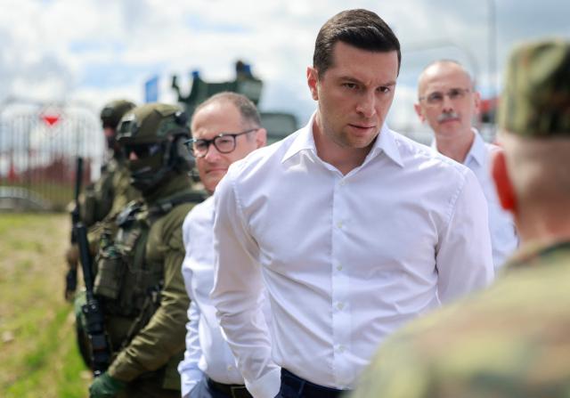 French far-right Rassemblement National (RN) party's President, member of the European Parliament and president of the Patriots for Europe (PfE) group Jordan Bardella (C) listens to Deputy Commander of the Podlaski Border Guard Unit Andrzej Stasiulewicz (R) during a visit to Poland's border with Belarus near Kuznica, eastern Poland on June 19, 2026. Jordan Bardella is on a two day visit to poland meeting with leaders of Polands far right and touring the eastern border, marking the latest stop on his overseas tour aimed at strengthening his European alliances just a few months before the French presidential election. (Photo by Wojtek RADWANSKI / AFP)