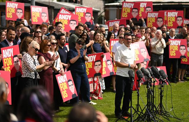 Marie-France van Heel (L), wife of new Labour Party MP for Makerfield, Andy Burnham, applauds her husband after he spoke to supporters and members of the media, the morning after his by-election victory, at Ashton Town FC, in Ashton in Makerfield, north-west England on June 19, 2026. Veteran UK Labour politician Andy Burnham emphatically won a crunch by-election on Friday, securing a parliamentary seat and clearing the way for a widely expected leadership challenge against beleaguered Prime Minister Keir Starmer. (Photo by Oli SCARFF / AFP)