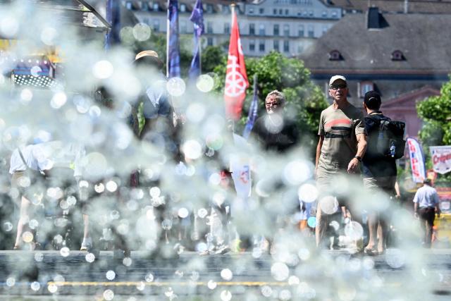 People walk past a fountain in central Mainz, western Germany, on June 19, 2026 with air temperature reaching 33 degrees Celsius. (Photo by Kirill KUDRYAVTSEV / AFP)