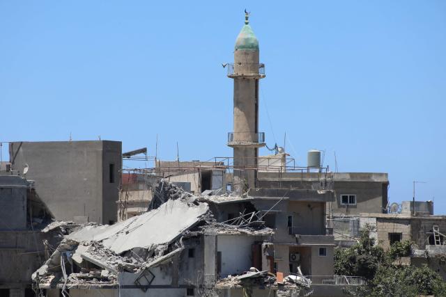 The minaret of a mosque stands behind a heavily damaged building at the site of an Israeli attack that destroyed houses and carpentry shops in the village of Al-Qlailah in the Tyre district in southern Lebanon on June 19, 2026. Deadly exchanges between Israel and Hezbollah in Lebanon put a newly signed deal to end the Middle East war under further strain, after the postponement of planned US-Iran talks in Switzerland. (Photo by KAWNAT HAJU / AFP)