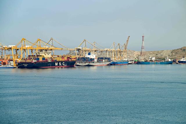 (L to R) The Liberia-flagged container vessel MSC Tasman VI, the Singapore-flagged container vessel Wan Hai 353, and other ships are docked along a pier at the Khor Fakkan Container Terminal, the only natural deep-sea port in the region and one of the major container ports in Sharjah Emirate, along the Gulf of Oman on June 19, 2026. Mediators in the US-Iran conflict, including Pakistan, Saudi Arabia and Turkey, are due to gather for talks in Egypt on June 21. A deal signed earlier in the week by US President Donald Trump and his Iranian counterpart Masoud Pezeshkian, aims to end the conflict that began on February 28 with US-Israeli strikes on Iran. It also provides for the reopening of the Strait of Hormuz and the launch of a 60-day negotiation period on broader issues, including Tehran's nuclear programme. (Photo by AFP) / 
