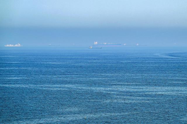 Cargo ships are pictured off cost of the Khor Fakkan Container Terminal, the only natural deep-sea port in the region and one of the major container ports in Sharjah Emirate, along the Gulf of Oman on June 19, 2026. Mediators in the US-Iran conflict, including Pakistan, Saudi Arabia and Turkey, are due to gather for talks in Egypt on June 21. A deal signed earlier in the week by US President Donald Trump and his Iranian counterpart Masoud Pezeshkian, aims to end the conflict that began on February 28 with US-Israeli strikes on Iran. It also provides for the reopening of the Strait of Hormuz and the launch of a 60-day negotiation period on broader issues, including Tehran's nuclear programme. (Photo by AFP) / 