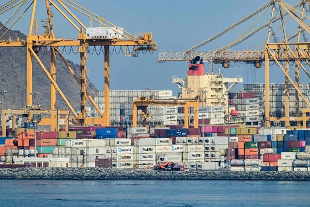 Containers are stacked along a pier at the Khor Fakkan Container Terminal, the only natural deep-sea port in the region and one of the major container ports in Sharjah Emirate, along the Gulf of Oman on June 19, 2026. Mediators in the US-Iran conflict, including Pakistan, Saudi Arabia and Turkey, are due to gather for talks in Egypt on June 21. A deal signed earlier in the week by US President Donald Trump and his Iranian counterpart Masoud Pezeshkian, aims to end the conflict that began on February 28 with US-Israeli strikes on Iran. It also provides for the reopening of the Strait of Hormuz and the launch of a 60-day negotiation period on broader issues, including Tehran's nuclear programme. (Photo by AFP) / 