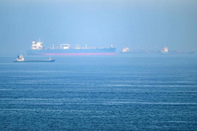 Cargo ships are pictured off cost of the Khor Fakkan Container Terminal, the only natural deep-sea port in the region and one of the major container ports in Sharjah Emirate, along the Gulf of Oman on June 19, 2026. Mediators in the US-Iran conflict, including Pakistan, Saudi Arabia and Turkey, are due to gather for talks in Egypt on June 21. A deal signed earlier in the week by US President Donald Trump and his Iranian counterpart Masoud Pezeshkian, aims to end the conflict that began on February 28 with US-Israeli strikes on Iran. It also provides for the reopening of the Strait of Hormuz and the launch of a 60-day negotiation period on broader issues, including Tehran's nuclear programme. (Photo by AFP) / 