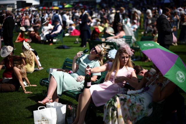 A racegoer uses a handheld fan on the fourth day of the Royal Ascot horse racing meeting in Ascot, west of London, on June 19, 2026. (Photo by Henry Nicholls / AFP)