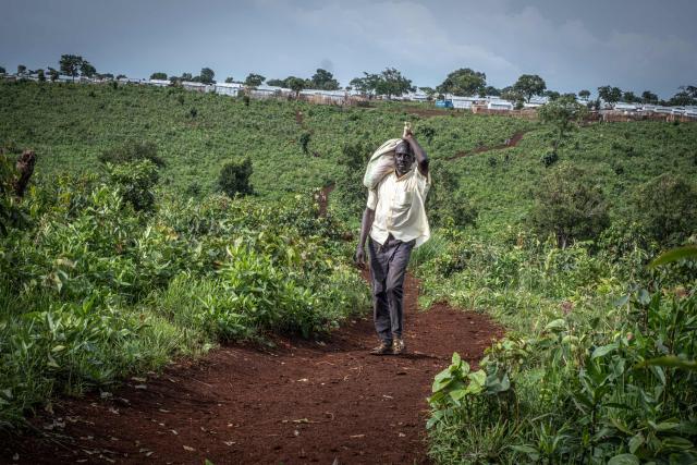 A Sudanese refugee man walks up a hill overlooking the Ura Refugee Site in Asosa Zone, Benishangul-Gumuz region, Ethiopia, on June 19, 2026. (Photo by Marco Simoncelli / AFP)