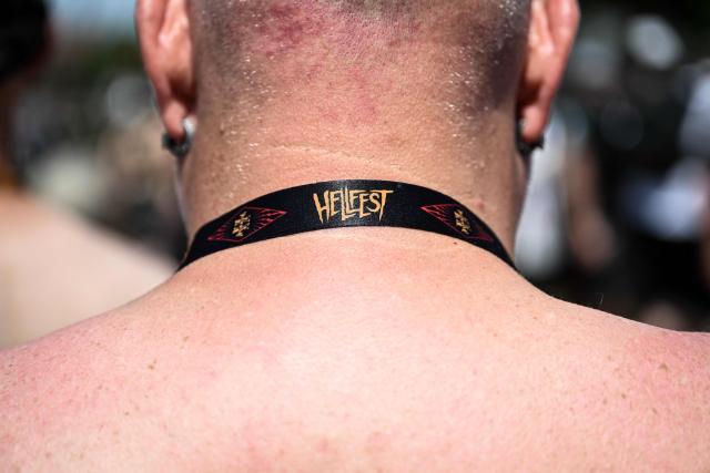 A festival goer wears a neck strap reading "Hellfest" during the 19th edition of Hellfest rock and heavy metal festival, in Clisson, western France, on June 19, 2026. (Photo by Sebastien Salom-Gomis / AFP)