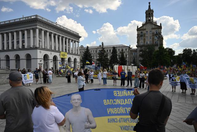 People hold placards as they participate in a meeting marking the International Day for the Elimination of Sexual Violence in Conflict on Independence Square in Kyiv on June 19, 2026, amid the Russian invasion of Ukraine. Several people, mostly women, took part in a demonstration on Kyiv’s central square on June 19, in support of Ukrainian civilian women imprisoned by Russian authorities. (Photo by Genya SAVILOV / AFP)