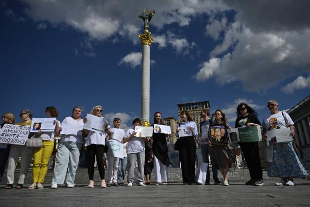 People hold placards as they participate in a meeting marking the International Day for the Elimination of Sexual Violence in Conflict on Independence Square in Kyiv on June 19, 2026, amid the Russian invasion of Ukraine. Several people, mostly women, took part in a demonstration on Kyiv’s central square on June 19, in support of Ukrainian civilian women imprisoned by Russian authorities. (Photo by Genya SAVILOV / AFP)