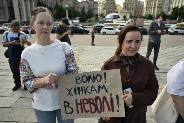 Participants hold a placard reading "Freedom to women who are in captivity" during a meeting marking the International Day for the Elimination of Sexual Violence in Conflict on Independence Square in Kyiv on June 19, 2026, amid the Russian invasion of Ukraine. Several people, mostly women, took part in a demonstration on Kyiv’s central square on June 19, in support of Ukrainian civilian women imprisoned by Russian authorities. (Photo by Genya SAVILOV / AFP)