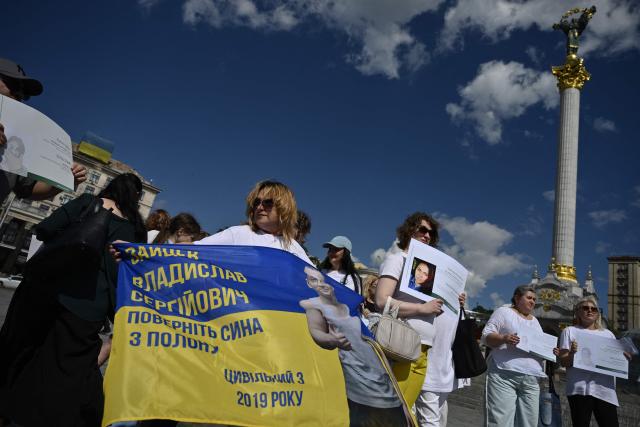 People hold placards as they participate in a meeting marking the International Day for the Elimination of Sexual Violence in Conflict on Independence Square in Kyiv on June 19, 2026, amid the Russian invasion of Ukraine. Several people, mostly women, took part in a demonstration on Kyiv’s central square on June 19, in support of Ukrainian civilian women imprisoned by Russian authorities. (Photo by Genya SAVILOV / AFP)