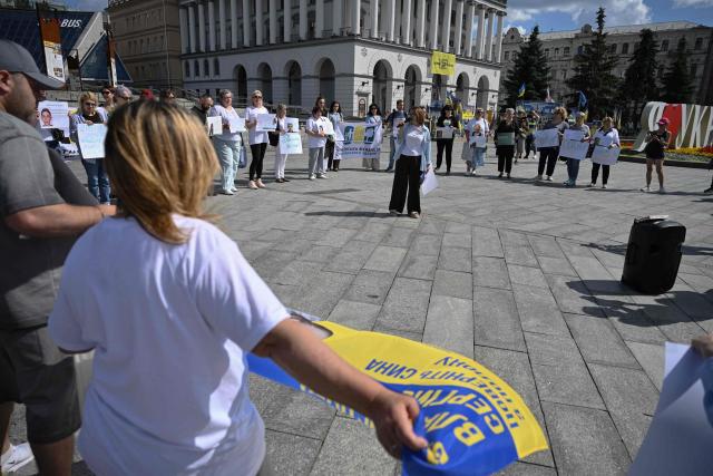 People hold placards as they participate in a meeting marking the International Day for the Elimination of Sexual Violence in Conflict on Independence Square in Kyiv on June 19, 2026, amid the Russian invasion of Ukraine. Several people, mostly women, took part in a demonstration on Kyiv’s central square on June 19, in support of Ukrainian civilian women imprisoned by Russian authorities. (Photo by Genya SAVILOV / AFP)