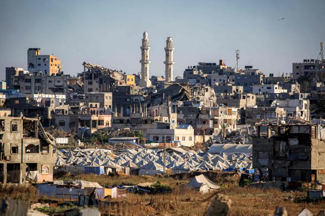 Shelters for people displaced by war are pictured pitched near heavily-damaged buildings at the Nuseirat camp for Palestinian refugees in the central Gaza Strip on June 19, 2026. Palestinian Islamist movement Hamas on Monday hailed a deal between the United States and Iran, expressing hope it would help put an end to violence in the Gaza Strip. Israel and Hamas trade near-daily accusations of truce violations and the Gaza Strip remains gripped by bloodshed as progress on permanently ending the war remains stalled. (Photo by Eyad Baba / AFP)