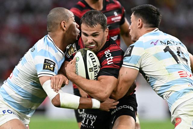 Racing 92' French winger Gael Fickou (L) and Racing 92' New Zaeland center Joseph Manu (R) attempt to tackle Toulouse's French scrum-half Antoine Dupont (C) during the French Top14 rugby union semi-final match between Stade Toulousain Rugby (Toulouse) and Racing 92 at the Velodrome stadium in Marseille, southern France on June 19, 2026. (Photo by Gabriel BOUYS / AFP)