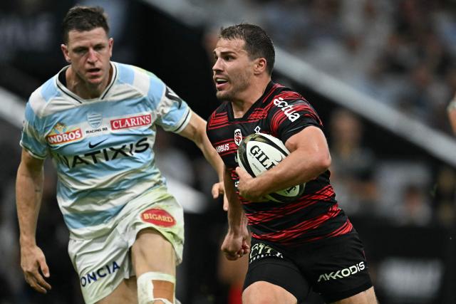 Toulouse's French scrum-half Antoine Dupont runs with the ball past Racing 92' English full back Sam James to score a try during the French Top14 rugby union semi-final match between Stade Toulousain Rugby (Toulouse) and Racing 92 at the Velodrome stadium in Marseille, southern France on June 19, 2026. (Photo by Gabriel BOUYS / AFP)