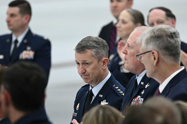 US chairman of the Joint Chiefs of Staff Gen. Dan Caine looks on as President Donald Trump speaks in front of the new Air Force One, gifted to him by Qatar, in a hangar at Joint Base Andrews in Maryland on June 19, 2026. White House officials bade farewell on June 18, 2026 to one of the two jets that have been used to transport US presidents for more than 30 years. The goodbye messages fueled speculation that a Boeing 747 controversially gifted to President Donald Trump by the Gulf emirate of Qatar is now due to enter service. Trump will be heading to Joint Base Andrews before spending the weekend at Camp David. (Photo by Brendan SMIALOWSKI / AFP)