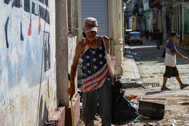 A man wearing a T-shirt with the US flag walks along a street of Havana on June 19, 2026. (Photo by YAMIL LAGE / AFP)