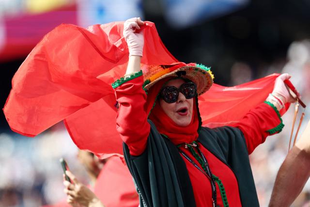 A Moroccan fan shows a national flag as she cheers for her team ahead of the 2026 World Cup Group C football match between Scotland and Morocco at the Boston Stadium in Foxborough on June 19, 2026.  (Photo by FRANCK FIFE / AFP)