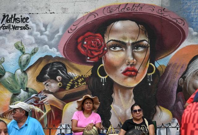 Teachers from the National Coordinator of Education Workers (CNTE), who have been protesting for weeks demanding salary increases and opposing the FIFA World Cup, stand during a protest in front of a mural at the Ministry of the Interior in Mexico City on June 19, 2026. (Photo by Yuri CORTEZ / AFP)
