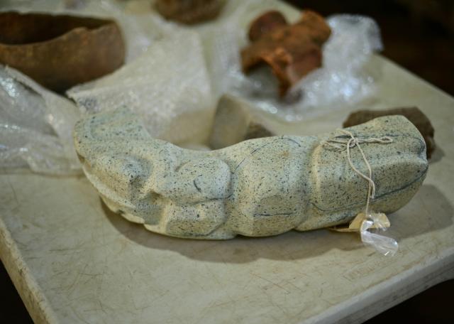 A green stone “yoke” depicting a batrachian is seen among objects found at an archaeological site and undergoing classification and documentation in Coatepec, Veracruz, Mexico on June 18, 2026. Mexican archaeologists have discovered the remains of a structure and a sculpture bearing features similar to those of the Maya culture and other characteristics described as “never before seen” in the eastern state of Veracruz. (Photo by Marco Antonio MARTINEZ / AFP)