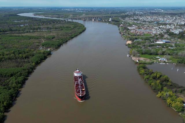 (FILES) Aerial view of a boat sailing on the Parana River near the Zarate port in Zarate, Buenos Aires province, taken on September 18, 2025. The Argentine government confirmed on June 19, 2026 that the consortium comprising the Belgian company Jan De Nul and the local firm Servimagnus will hold a 25-year concession for the dredging and marking of the Parana-Paraguay waterway, through which 80 per cent of the country's exports are transported. (Photo by Luis ROBAYO / AFP)