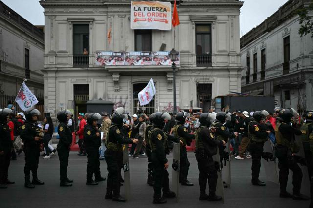 Riot police stand guard as supporter of Peru's presidential candidate for the Juntos por el Peru party, Roberto Sanchez, take part in a protest in Lima on June 19, 2026. Peru's neck-and-neck presidential election pitting conservative Keiko Fujimori against leftist Roberto Sanchez is one of the tightest leadership contests Latin America has seen in decades, an AFP analysis showed. (Photo by ERNESTO BENAVIDES / AFP)