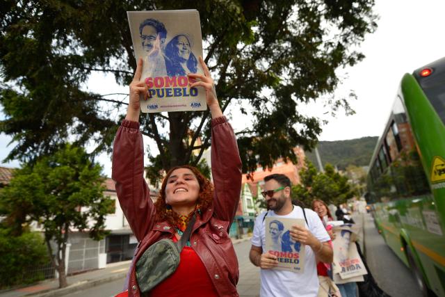 Supporters of Colombia's presidential candidate Ivan Cepeda distribute campaign posters bearing his image alongside running mate Aida Quilcue, reading "Somos Pueblo" (We are the people), in Bogota on June 19, 2026. Colombians vote on June 21, 2026 in a presidential runoff pitting a hard-right opera-singer-turned-lawyer against a leftist senator, an election with stark consequences for the country's stumbling peace process with armed groups and strained ties with Washington. (Photo by Sebastian BARROS / AFP)