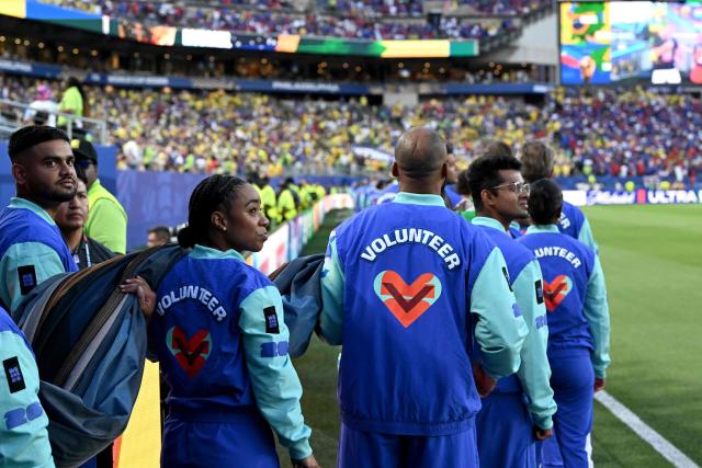 FIFA volunteers walk onto the pitch ahead of the 2026 World Cup Group C football match between Brazil and Haiti at the Philadelphia Stadium in Philadelphia on June 19, 2026.  (Photo by ROBERTO SCHMIDT / AFP)
