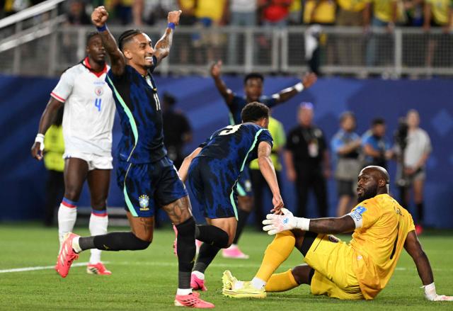 Brazil's forward #09 Matheus Cunha (C) celebrates scoring his team's first goal past Haiti's goalkeeper #01 Johny Placide (R) during the 2026 World Cup Group C football match between Brazil and Haiti at the Philadelphia Stadium in Philadelphia on June 19, 2026.  (Photo by ROBERTO SCHMIDT / AFP)