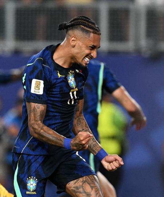 Brazil's forward #11 Raphinha celebrates his team's first goal scored by forward #09 Matheus Cunha (in the background) during the 2026 World Cup Group C football match between Brazil and Haiti at the Philadelphia Stadium in Philadelphia on June 19, 2026.  (Photo by ROBERTO SCHMIDT / AFP)