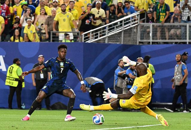 Brazil's forward #07 Vinicius Junior scores his team's third goal past Haiti's goalkeeper #01 Johny Placide during the 2026 World Cup Group C football match between Brazil and Haiti at the Philadelphia Stadium in Philadelphia on June 19, 2026.  (Photo by ROBERTO SCHMIDT / AFP)