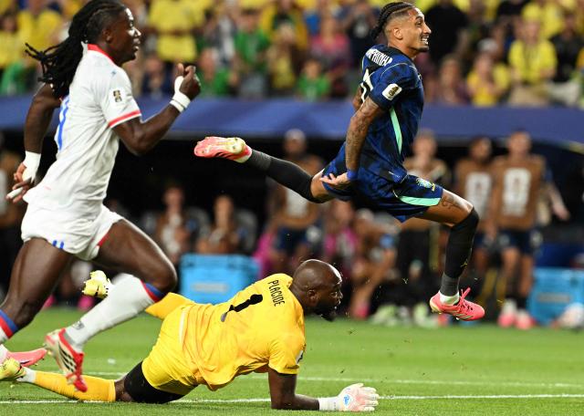 Brazil's forward #11 Raphinha eludes Haiti's goalkeeper #01 Johny Placide during the 2026 World Cup Group C football match between Brazil and Haiti at the Philadelphia Stadium in Philadelphia on June 19, 2026.  (Photo by ROBERTO SCHMIDT / AFP)