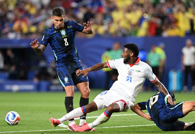 Brazil's midfielder #08 Bruno Guimaraes, Haiti's forward #21 Josue Casimir, and Brazil's defender #16 Douglas Santos fight for the ball during the 2026 World Cup Group C football match between Brazil and Haiti at the Philadelphia Stadium in Philadelphia on June 19, 2026.  (Photo by ROBERTO SCHMIDT / AFP)