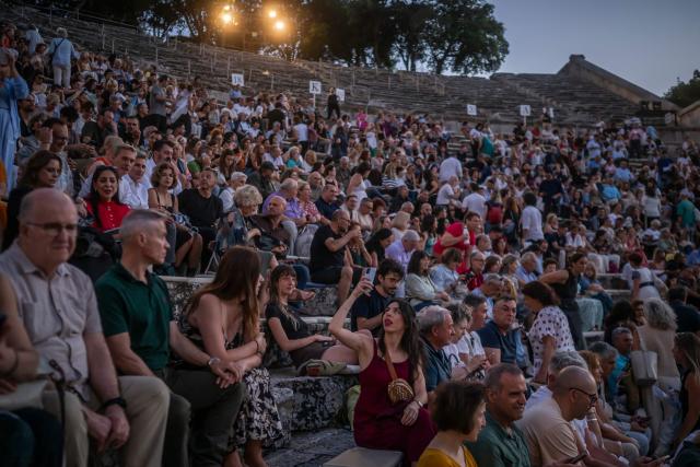 Spectators wait for the start of the opera 'Medea' at the Ancient Greek theatre of former city Epidaurus, in Nea Epidavros on June 18, 2026. With flamboyant costumes reminiscent of those from 1961, and a production reconstructed using notebooks and photographs from the period: 'Medea', the opera that brought Maria Callas her triumph, is being revived at the ancient Greek theatre of Epidaurus. During a one-off, sold-out performance on Saturday evening, the Greek National Opera returns for the first time in 65 years to this 4th-century BC amphitheatre, 200 kilometres from Athens, renowned for its exceptional acoustics. (Photo by Aris MESSINIS / AFP)