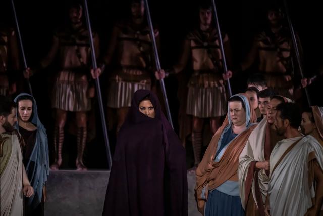 Italian soprano Anna Pirozzi (C) performs in the opera 'Medea' at the Ancient Greek theatre of former city Epidaurus, in Nea Epidavros on June 18, 2026. With flamboyant costumes reminiscent of those from 1961, and a production reconstructed using notebooks and photographs from the period: 'Medea', the opera that brought Maria Callas her triumph, is being revived at the ancient Greek theatre of Epidaurus. During a one-off, sold-out performance on Saturday evening, the Greek National Opera returns for the first time in 65 years to this 4th-century BC amphitheatre, 200 kilometres from Athens, renowned for its exceptional acoustics. (Photo by Aris MESSINIS / AFP)
