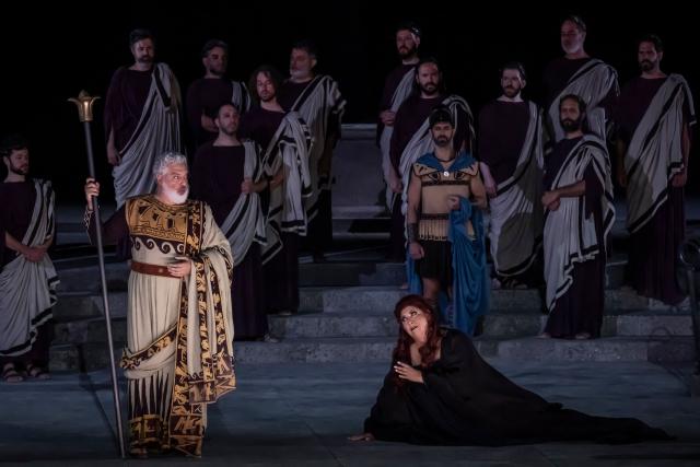 Italian soprano Anna Pirozzi (R) and Greek operatic baritone Tassis Christoyannis perform in the opera 'Medea' at the Ancient Greek theatre of former city Epidaurus, in Nea Epidavros on June 18, 2026. With flamboyant costumes reminiscent of those from 1961, and a production reconstructed using notebooks and photographs from the period: 'Medea', the opera that brought Maria Callas her triumph, is being revived at the ancient Greek theatre of Epidaurus. During a one-off, sold-out performance on Saturday evening, the Greek National Opera returns for the first time in 65 years to this 4th-century BC amphitheatre, 200 kilometres from Athens, renowned for its exceptional acoustics. (Photo by Aris MESSINIS / AFP)
