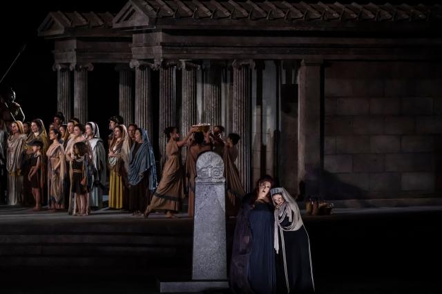 Italian soprano Anna Pirozzi (2nd R) performs in the opera 'Medea' at the Ancient Greek theatre of former city Epidaurus, in Nea Epidavros on June 18, 2026. With flamboyant costumes reminiscent of those from 1961, and a production reconstructed using notebooks and photographs from the period: 'Medea', the opera that brought Maria Callas her triumph, is being revived at the ancient Greek theatre of Epidaurus. During a one-off, sold-out performance on Saturday evening, the Greek National Opera returns for the first time in 65 years to this 4th-century BC amphitheatre, 200 kilometres from Athens, renowned for its exceptional acoustics. (Photo by Aris MESSINIS / AFP)