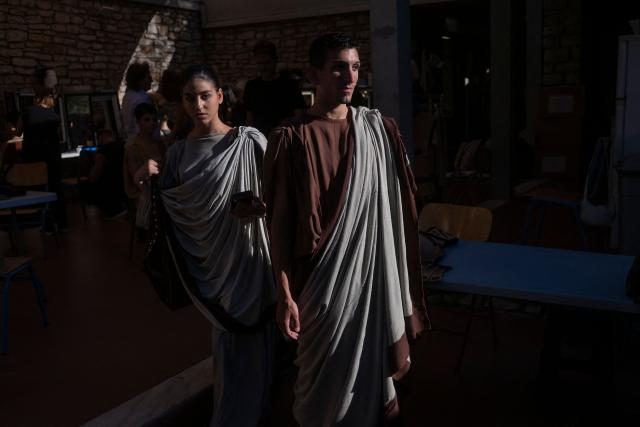 Actors prepare backstage to perform in the opera 'Medea' at the Ancient Greek theatre of former city Epidaurus, in Nea Epidavros on June 18, 2026. With flamboyant costumes reminiscent of those from 1961, and a production reconstructed using notebooks and photographs from the period: 'Medea', the opera that brought Maria Callas her triumph, is being revived at the ancient Greek theatre of Epidaurus. During a one-off, sold-out performance on Saturday evening, the Greek National Opera returns for the first time in 65 years to this 4th-century BC amphitheatre, 200 kilometres from Athens, renowned for its exceptional acoustics. (Photo by Aris MESSINIS / AFP)
