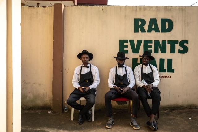 Members of the caterer sit outside the venue during the traditional wedding ceremony of twin brothers Taiwo and Kehinde Oguntoye and twin sisters Taiwo and Kehinde Adediran at the RAD Events Hall in Ibadan, on June 19, 2026. (Photo by OLYMPIA DE MAISMONT / AFP)